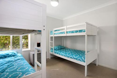 a bedroom with two bunk beds and a window at Riverside Views Hawks Nest in Hawks Nest
