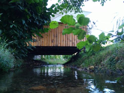 a wooden bridge over a stream with a river at Vikendica na Jazu in Kosjerić