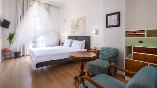 a bedroom with a bed and a table and a chair at The Caravan in Thessaloniki