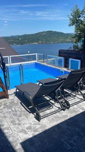 a swimming pool with two lounge chairs next to it at Casa Clau Cazare Orșova in Orşova