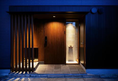 een toegang tot een gebouw met een houten deur bij 古今 天下茶屋 with a private parking lot and a half open-air bath and direct to KIX in Osaka