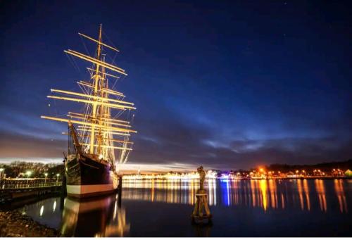 a tall ship docked in the water at night at Apartment Miesmuschelparadies in Lübeck