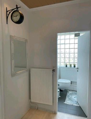 a bathroom with a toilet and a clock on the wall at Apartment Miesmuschelparadies in Lübeck