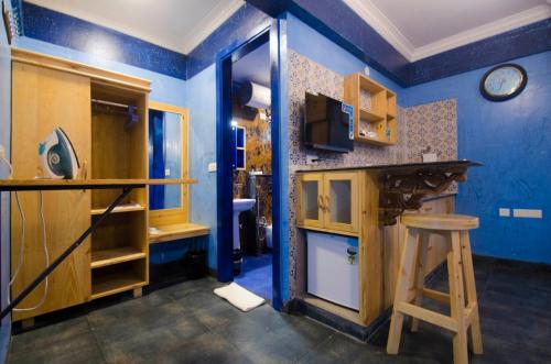 a blue kitchen with a counter and a stool at Liwa Habitat in Bangalore
