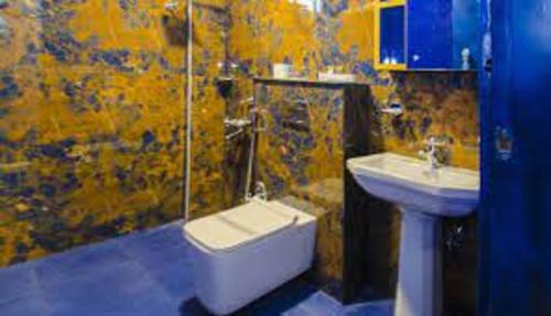 a bathroom with a sink and a shower and a toilet at Liwa Habitat in Bangalore
