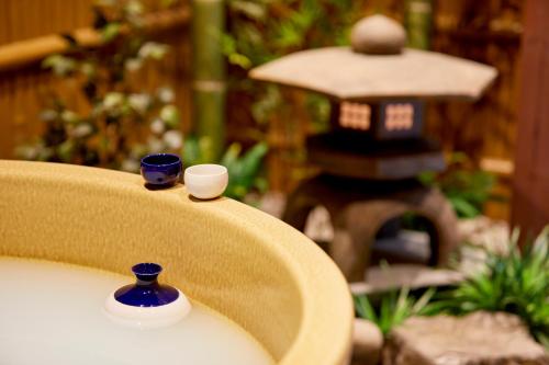 a chair with two blue vases and a bird house at 古今 天下茶屋 with a private parking lot and a half open-air bath and direct to KIX in Osaka
