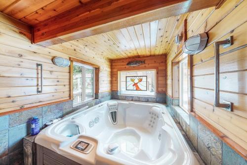 a large tub in a bathroom with wooden walls and ceilings at Downhill Beaverhead in Big Sky
