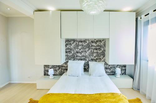 um quarto com uma grande cama branca e 2 almofadas em Tranokely em Antananarivo