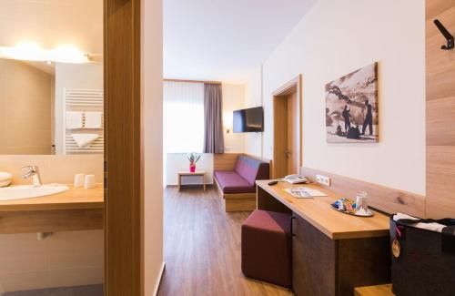 a hotel room with a sink and a bathroom at Panoramahotel Gürtl in Haus im Ennstal