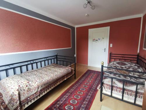 two beds in a room with red walls at Shiraz-Home Ferienhaus in Holzminden an der Weser in Holzminden