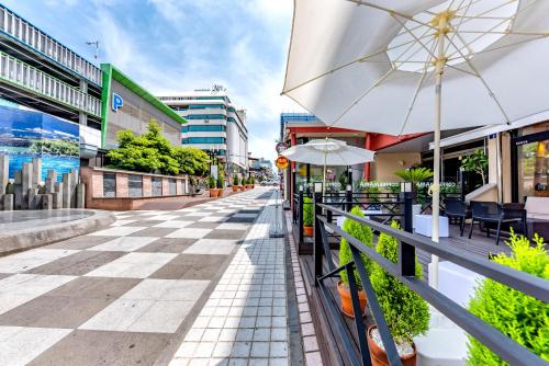 an empty street with tables and an umbrella at Trevi Hotel in Jeju