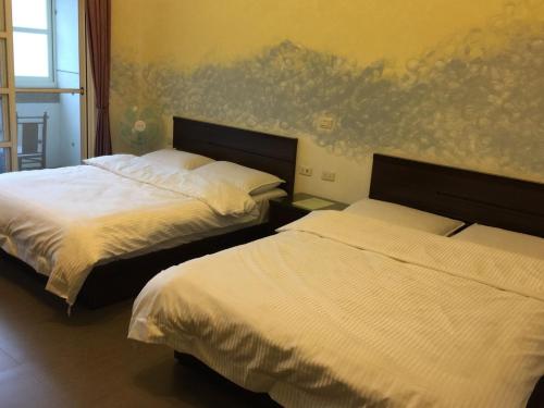 冬山鄉的住宿－松舍民宿，一间卧室配有两张床和壁画