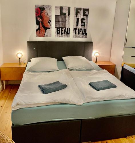 a bed with two pillows on it in a bedroom at Nana-EG-80m2 sanierter Altbau-Parkplatz-kleiner Garten-WLAN-NETFLIX-2Zimmer-Küche-Dusche-Wanne-Waschmaschine in Oberhausen