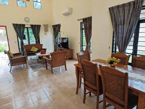 sala de estar con mesa y sillas en A'Famosa Villa 884, en Kampong Alor Gajah