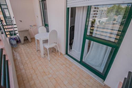 ファロにあるCharming Private Rooms in an Apartment A1 Penha - Faroのテーブルと椅子、窓が備わる客室です。