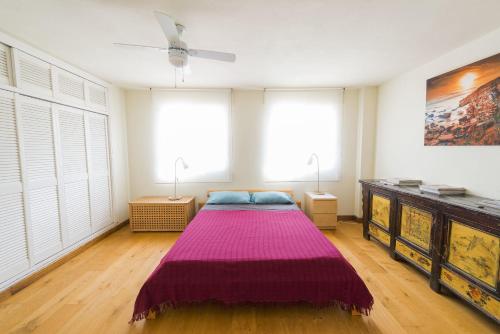 タリファにあるApartamento con terrazaのベッドルーム(紫の毛布付きのベッド1台付)