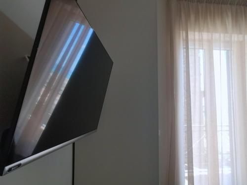 a flat screen tv on a wall next to a window at Casa Vacanze Vicolo San Pietro in Agrigento
