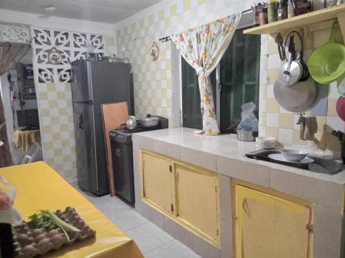 a kitchen with yellow cabinets and a black refrigerator at Posada Green Sea San Luis pesos with breakfast included starting in March in Cueva de Morgan