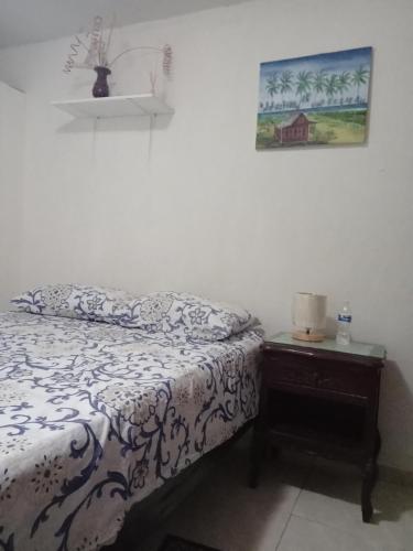 a bedroom with a bed and a table with a picture on the wall at Posada Green Sea San Luis pesos with breakfast included starting in March in Cueva de Morgan