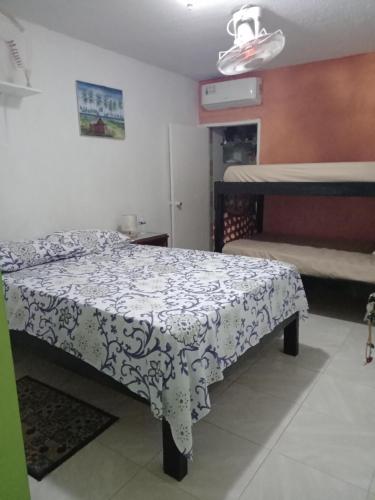 a bedroom with a bed with a black and white blanket at Posada Green Sea San Luis pesos with breakfast included starting in March in Cueva de Morgan