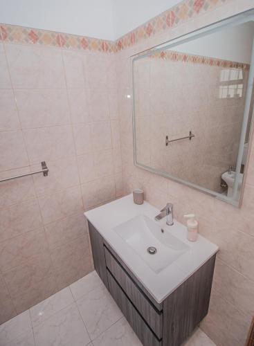 a bathroom with a sink and a mirror at Charming Private Rooms in an Apartment A1 Penha - Faro in Faro