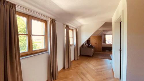 an empty hallway with two windows and a living room at Hotel Restaurant Häupl in Seewalchen