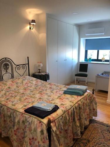 a bedroom with a large bed with a flowered blanket at Grandfather's House in Tábua