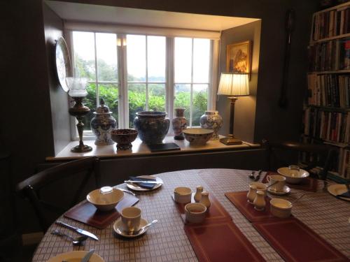 a table with plates and cups and a window at Slack Cottage in High Wray