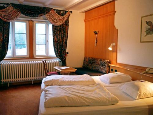 ラ・プティット・ピエールにあるAuberge d'Imsthalのベッド2台と窓が備わるホテルルームです。