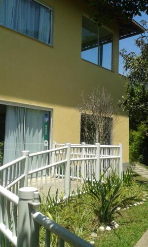 a white picket fence in front of a house at Pousada Matitaterê in Teresópolis