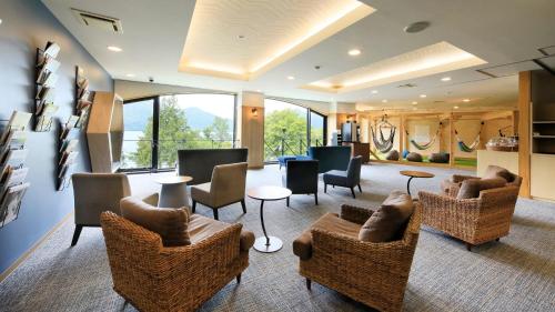 a lobby with couches and chairs and windows at Yutorelo Nikko in Nikko