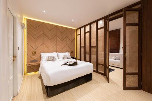 a bedroom with a large white bed and a bathroom at Botanic Service Room at Impact Muangthongthani - SHA Certified in Nonthaburi