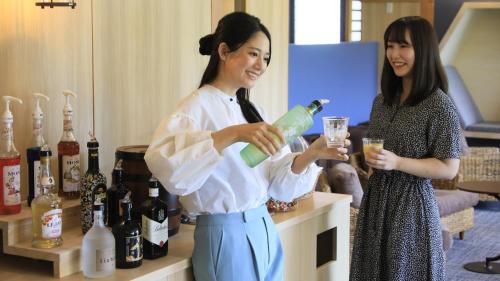 two women standing in a room with wine bottles at Yutorelo Nikko in Nikko
