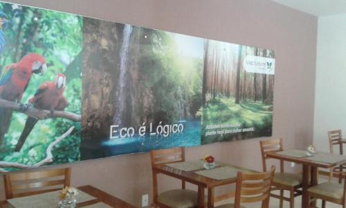 a restaurant with two tables and a large screen at Pousada Matitaterê in Teresópolis