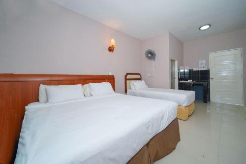 a bedroom with two beds and a kitchen at Mila Motel 2 in Pantai Cenang