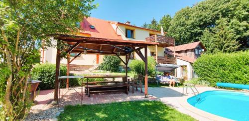 un patio trasero con pérgola de madera y piscina en Apartment Ulrich, en Jablonec nad Jizerou