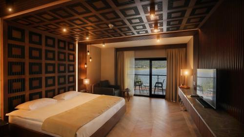 a bedroom with a large bed and a balcony at Abant Kosk Oteli in Abant