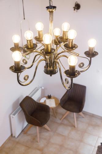 a chandelier with two chairs in a room at Magtár Villa in Bóly