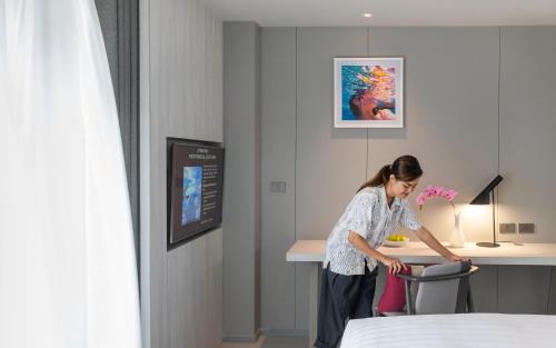 a woman standing at a desk in a hotel room at U Jomtien Pattaya in Jomtien Beach