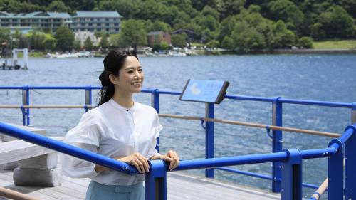a woman standing on a pier near the water at Yutorelo Nikko in Nikko