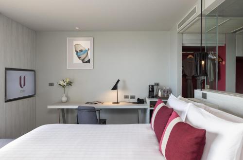 a bedroom with a white bed with red pillows at U Jomtien Pattaya in Jomtien Beach