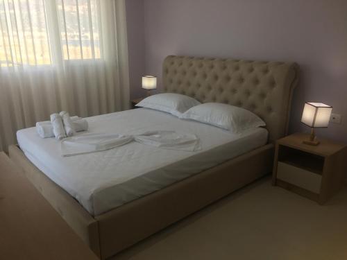 a large bed with white sheets and white pillows at Linda’s apartment in Vlorë