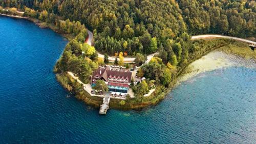 une grande maison sur une île dans l'eau dans l'établissement Abant Kosk Oteli, à Abant