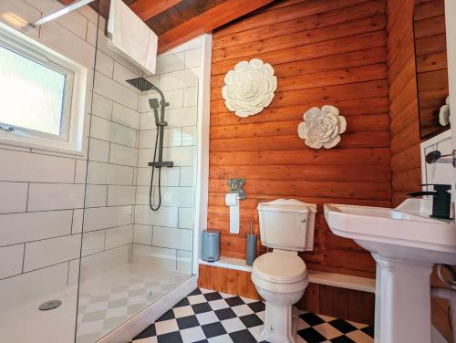 a bathroom with a toilet and a shower and a sink at Kaoglen-Stags-Hot tub-Cairngorms-Pet Friendly in Balnald