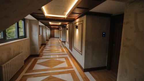 a hallway with a tile floor and a ceiling with lights at Abant Kosk Oteli in Abant