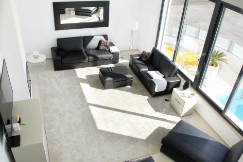 einen Blick über ein Wohnzimmer mit schwarzen Möbeln in der Unterkunft Villa Secret Spot Luxury in Lourinhã