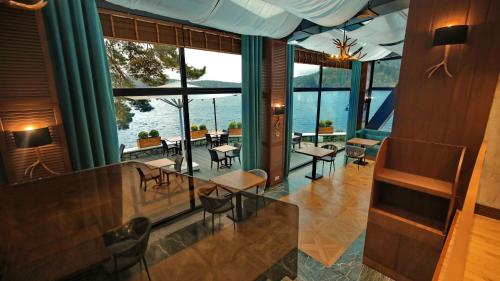 a hotel lobby with tables and chairs and windows at Abant Kosk Oteli in Abant