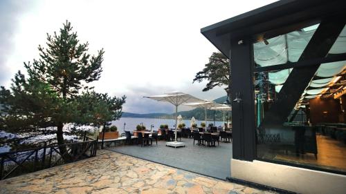 a restaurant with tables and chairs and a view of the water at Abant Kosk Oteli in Abant