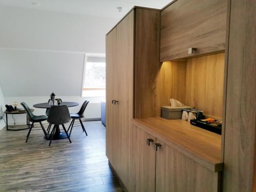 a kitchen with a large wooden cabinet and a table at Hotel Erve Hulsbeek in Oldenzaal