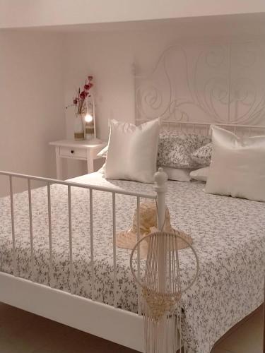 Dormitorio blanco con cama con colcha blanca en Villetta con Piscina e Campo da Tennis condominiale en Villasimius